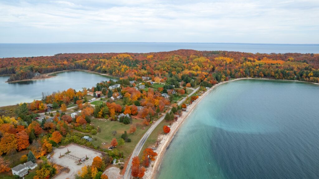 Aerial view of an autumnal scene of trees on the banks of a Cut River, in Michigan