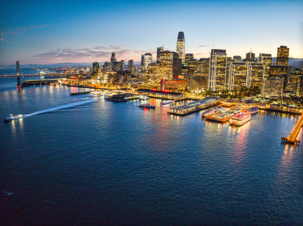 Aerial view of San Francisco city skyline at sunset, illuminated by the city lights