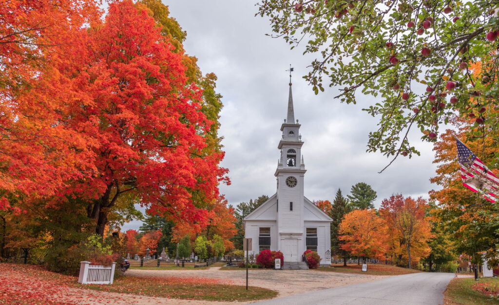 Beautiful shot of the Sandwich new Hampshire church surrounded by autumn trees