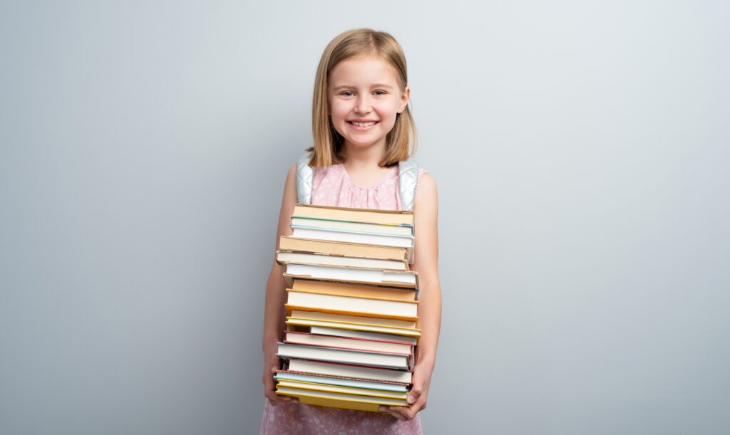 Little girl with backpack and textbooks